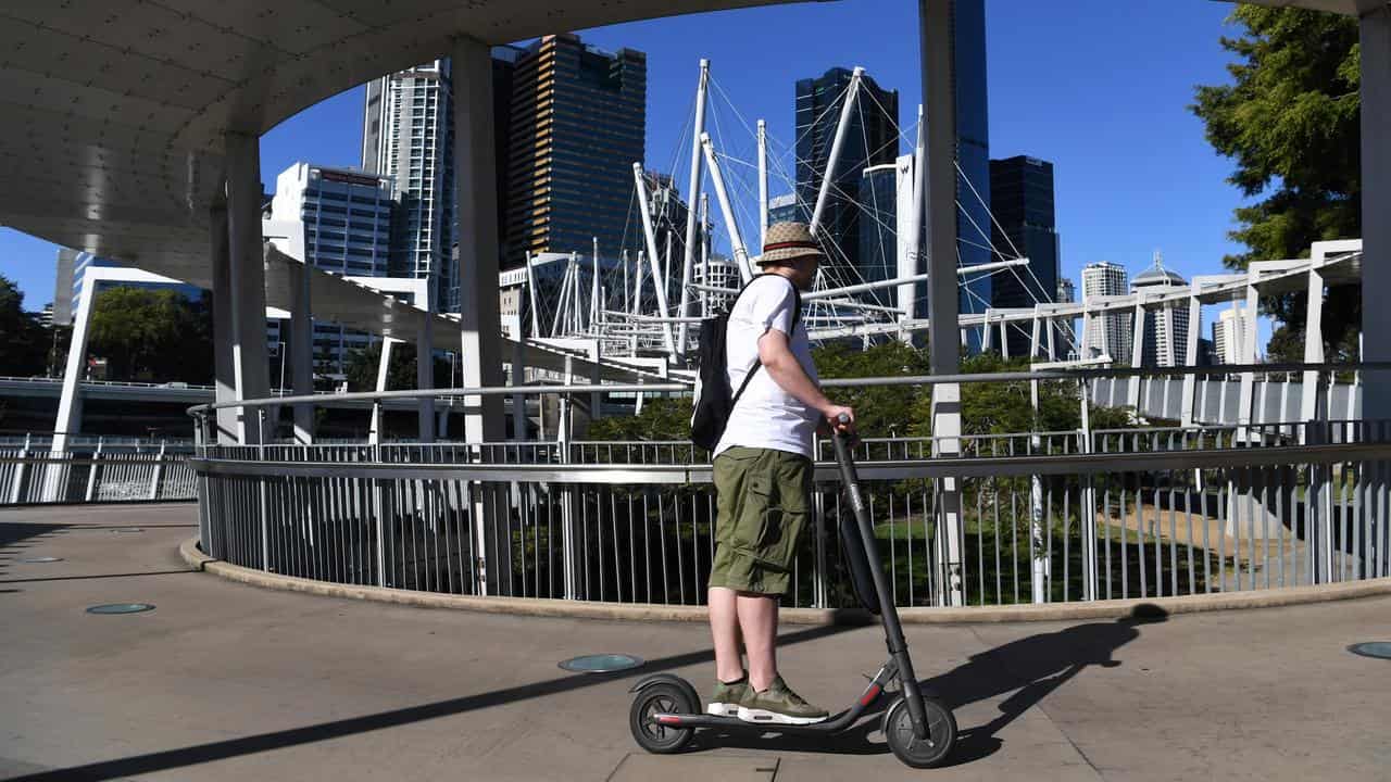 A man riding a personal e-scooter in Brisbane.