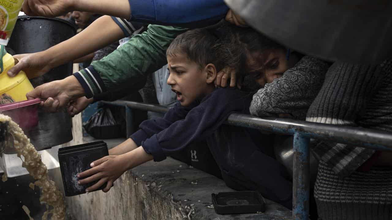 Palestinians line up for a free meal in Rafah, Gaza Strip