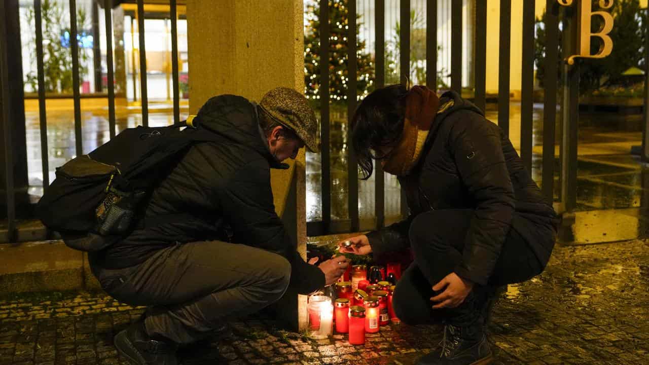 A woman lights candles at Charles University in Prague