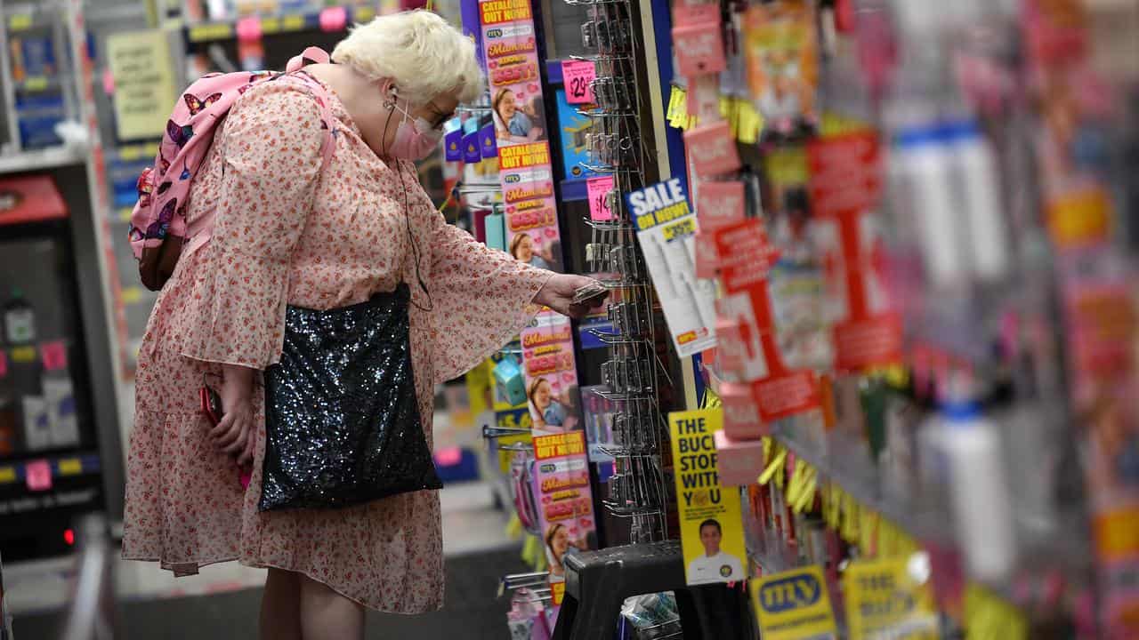 An older woman shopping at a discount chemist.