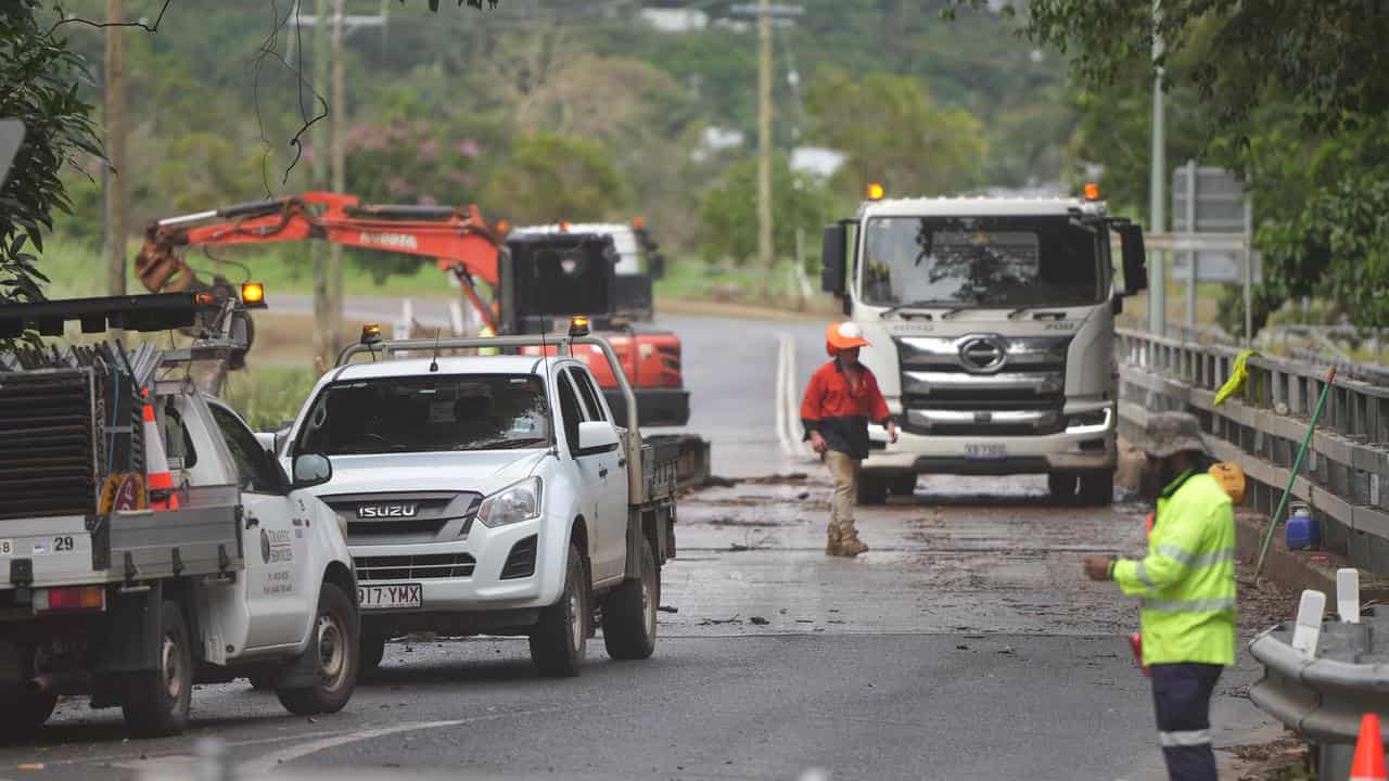 Workers clean up after flooding at Stratford Bridge in Cairns.