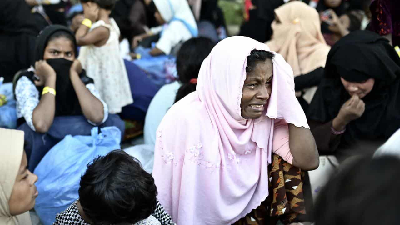 Rohingya woman weeps after being removed from temporary shelter