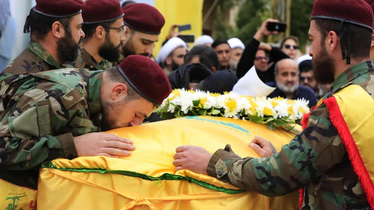 A Hezbollah fighter kisses the coffin of Ali Bazzi.