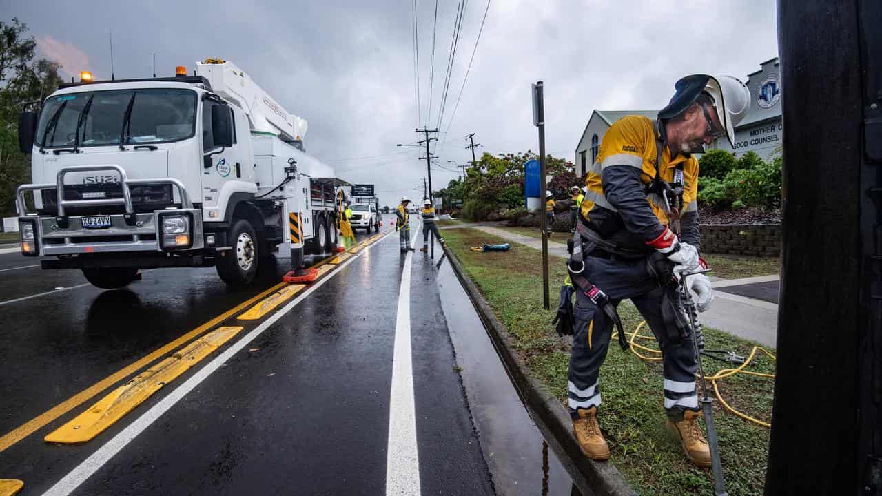 Ergon electrician Justin Pitts fixes a broken power line in Cairns