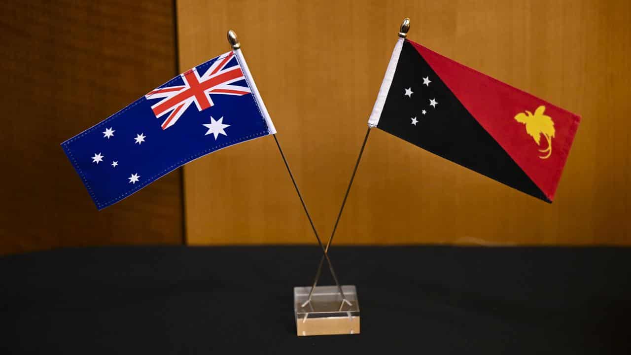 An Australian flag and the flag of Papua New Guinea