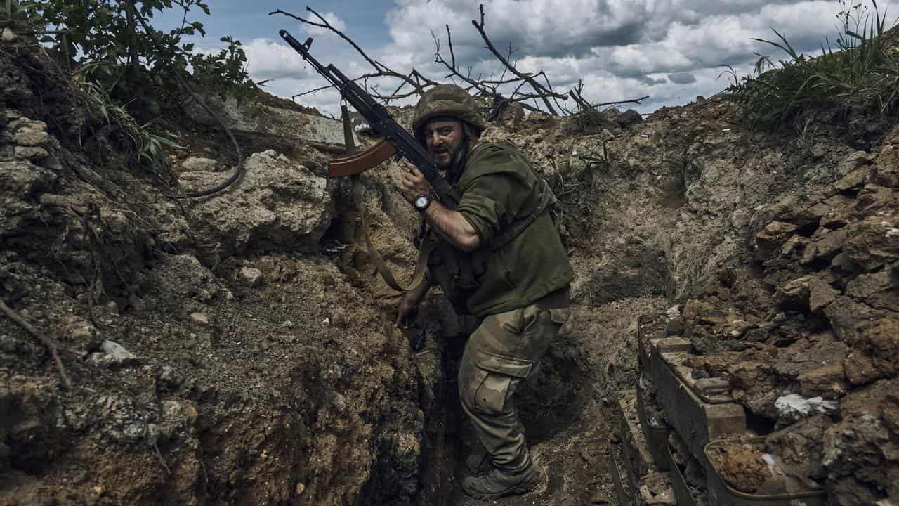 A Ukrainian soldier is seen in a trench at the frontline