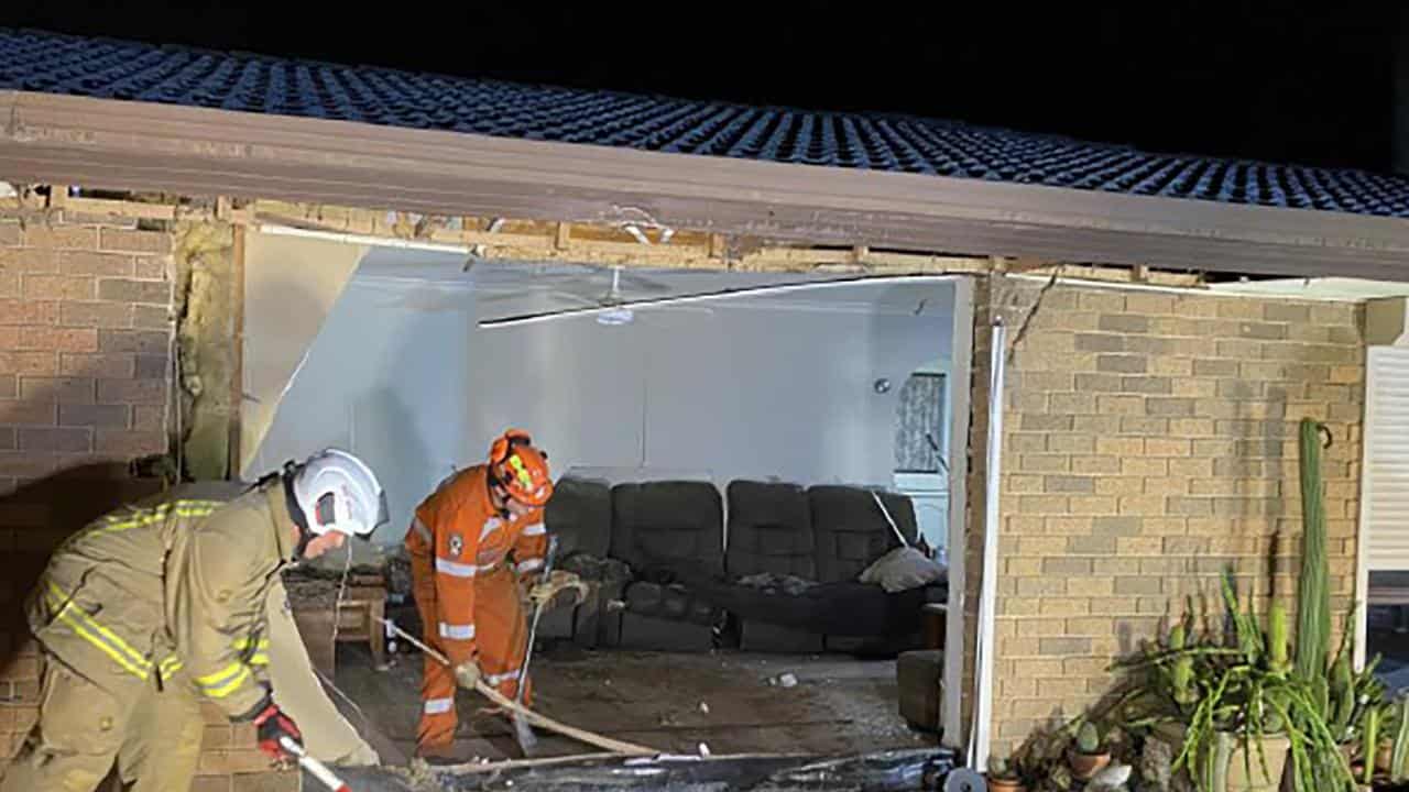 Workers clean up damage after a van crashed through the wall