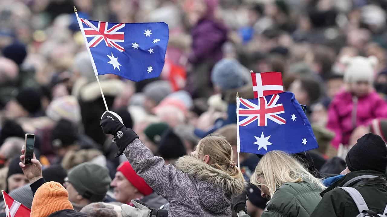 A spectator waves Australian flags