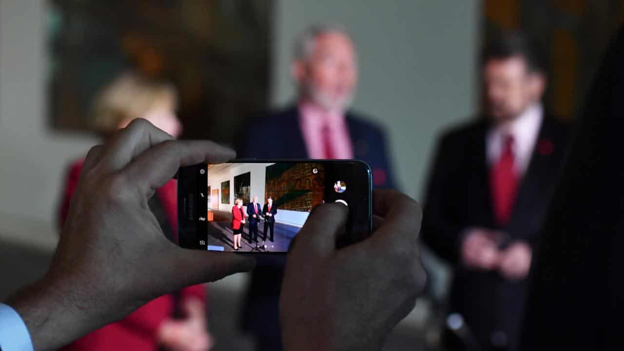 Staffer takes photo of politicians at Parliament House in Canberra.