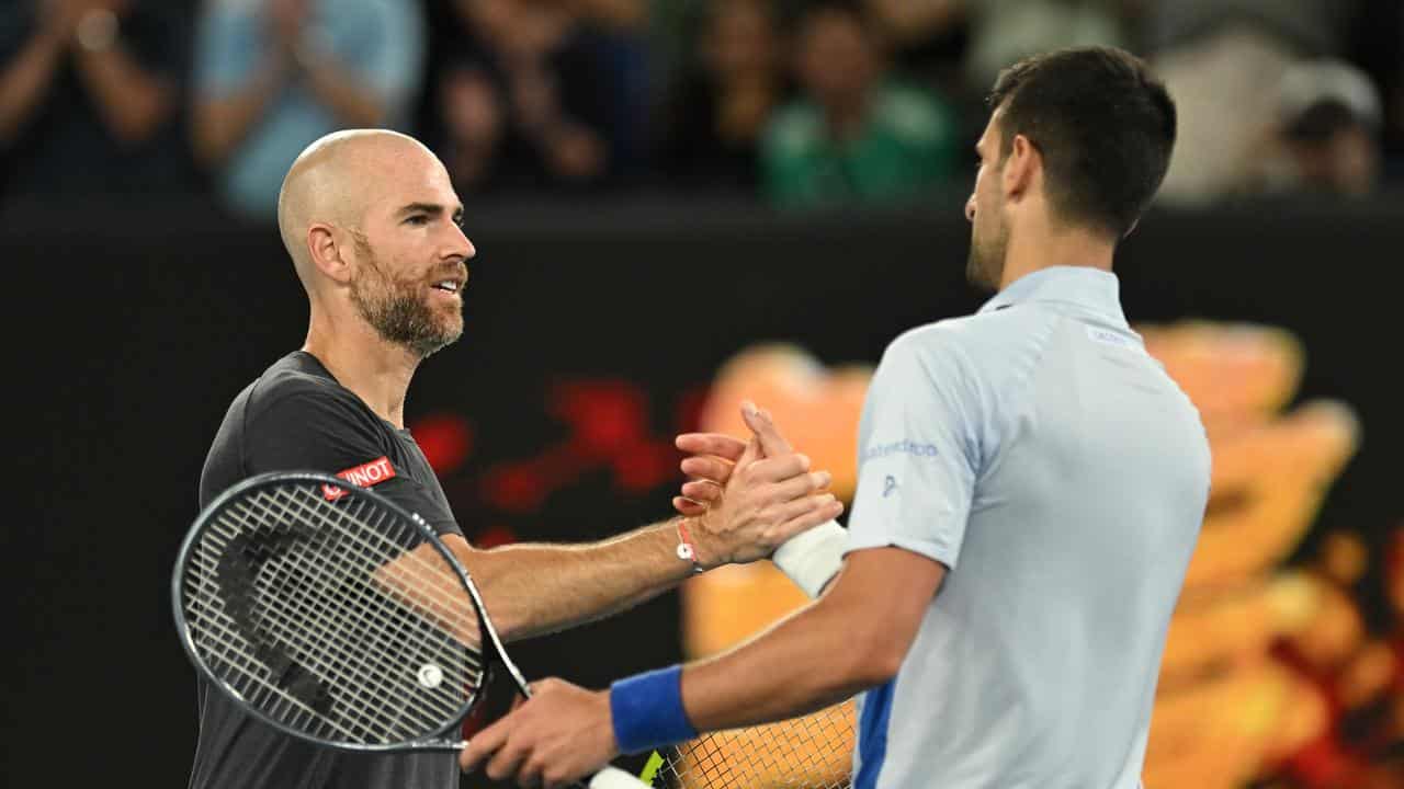 Djokovic and Mannarino shake hands after the match.