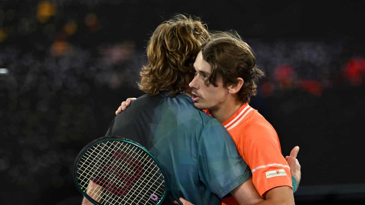 Alex de Minaur and Andrey Rublev embrace at the net after the match.