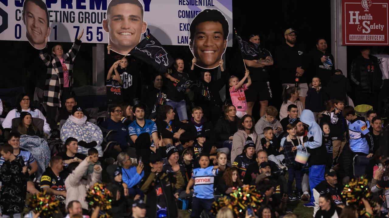 Panthers fans hold up player head posters during a home match in 2023.