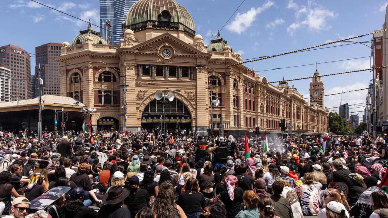 People sit at the intersection of Flinders Street Station