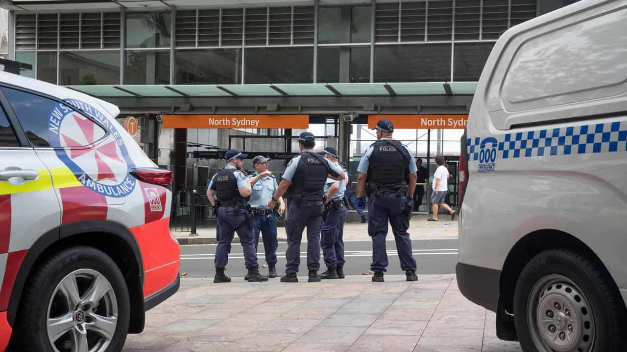 Police officers stand outside the North Sydney train station.