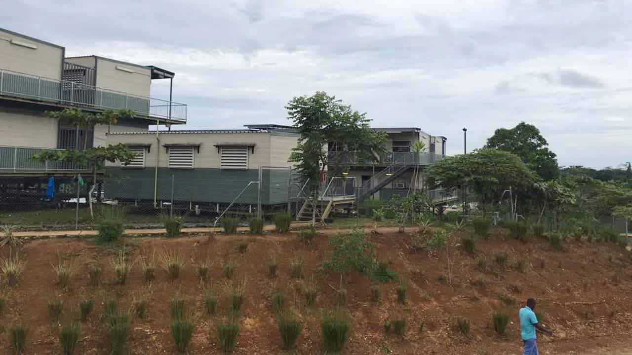 A man walking past the refugee processing centre on Manus Island, PNG