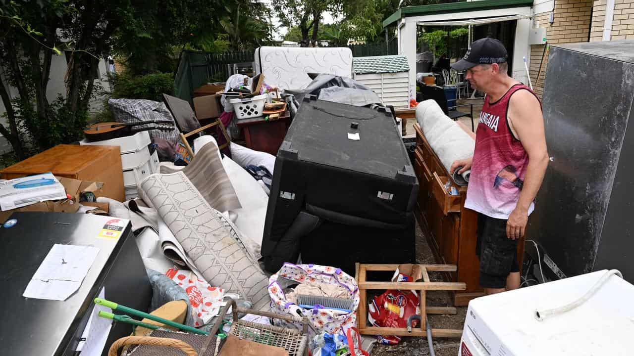 Kyle Blair with damaged furniture and electrical pile