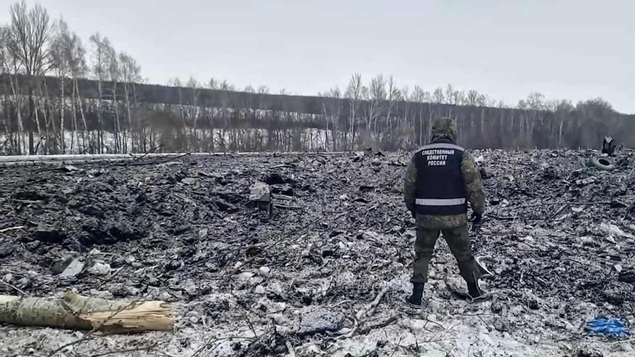 Investigator walks in field where Russian plane crashed