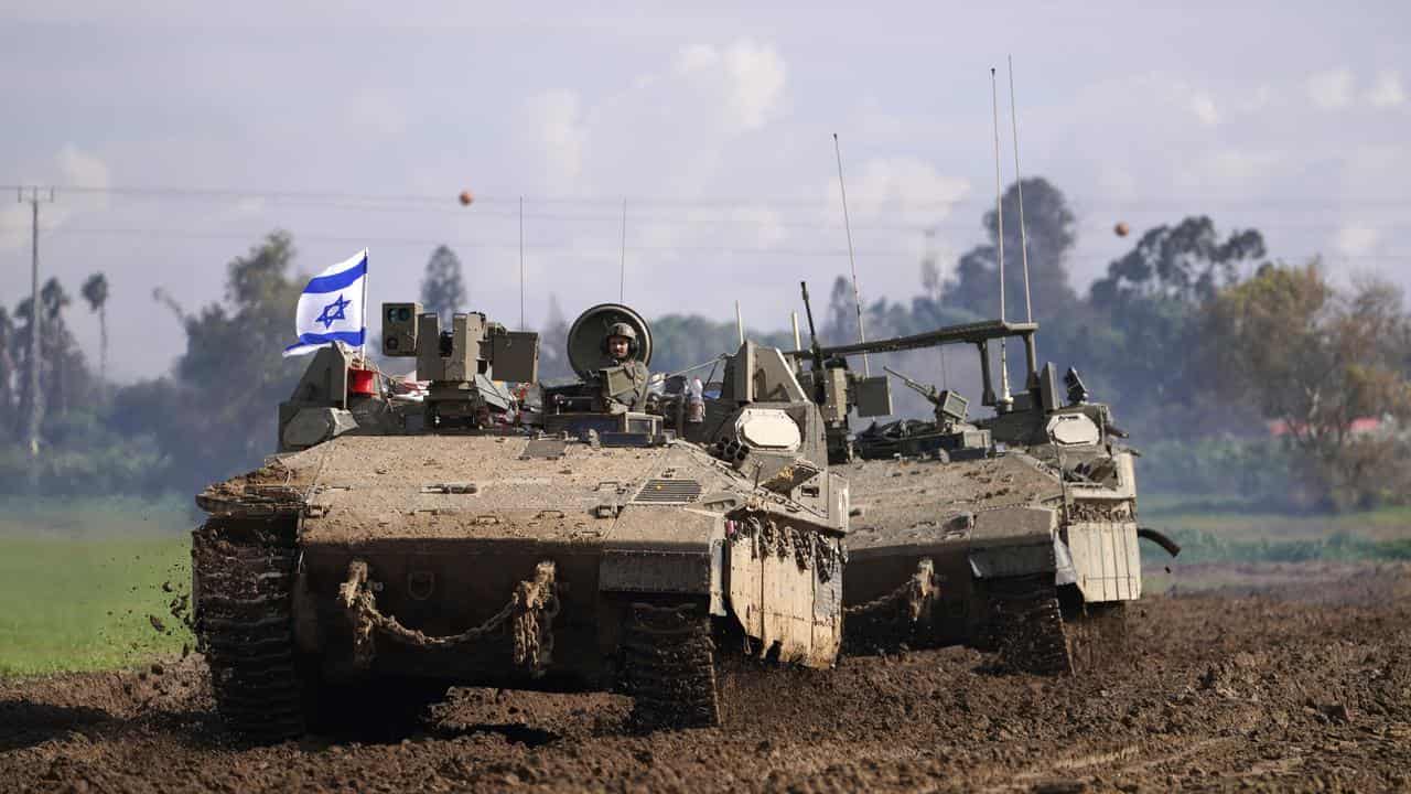 Israeli soldiers drive in their armoured vehicles near the Gaza border