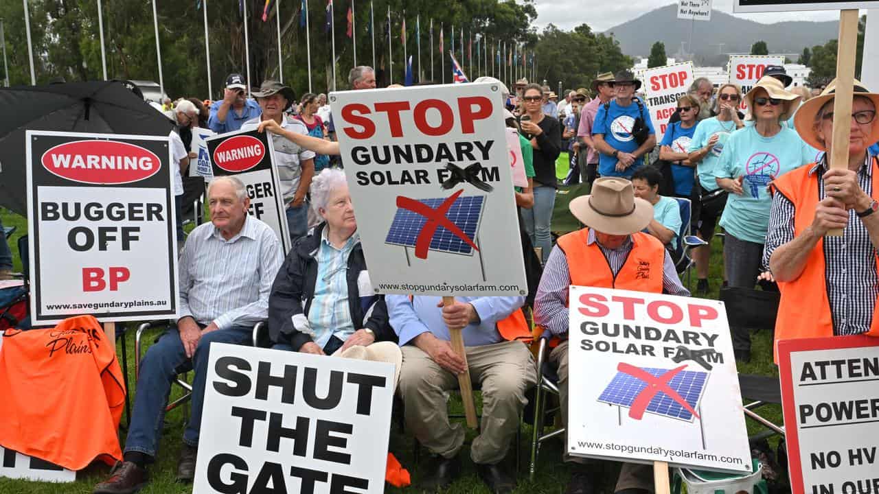 Protesters with anti-renewables signs