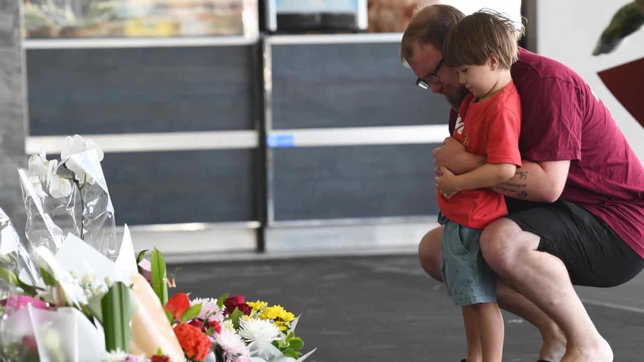 Residents lay flowers near a crime scene in Ipswich, West of Brisbane