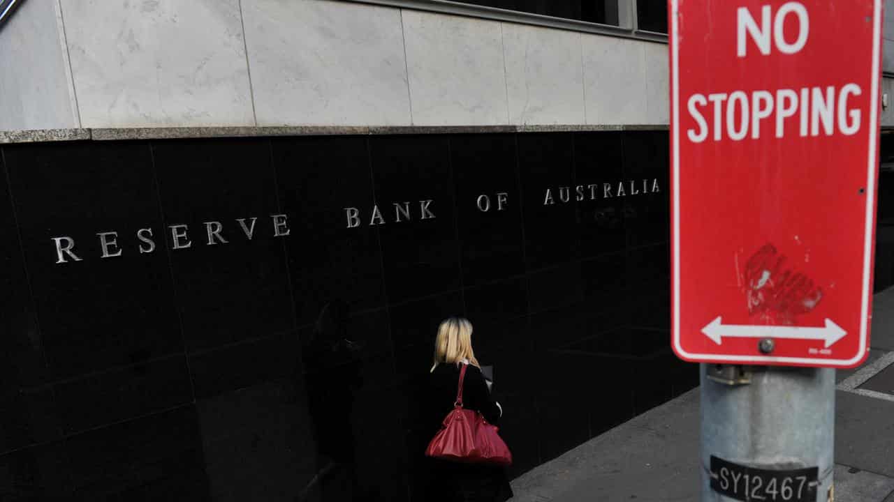 A woman passes the RBA building in Sydney (file image)