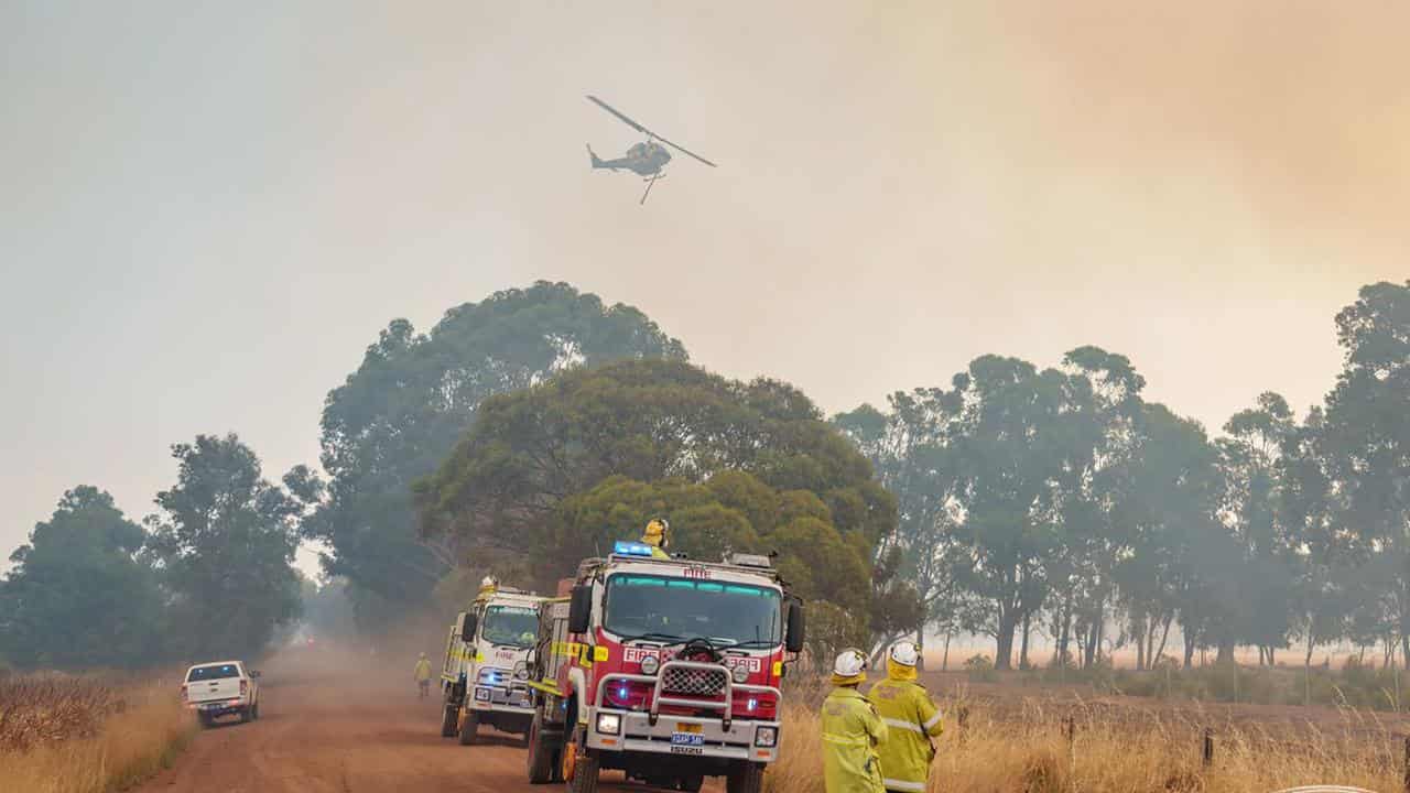 A helicopter and firecrews near a bushfire in Keysbrook, Perth.