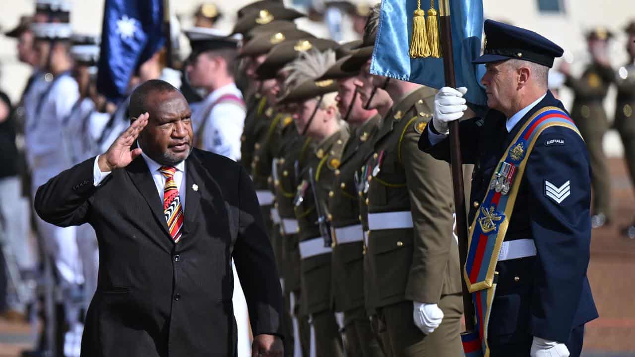 James Marape inspects a guard of honour.