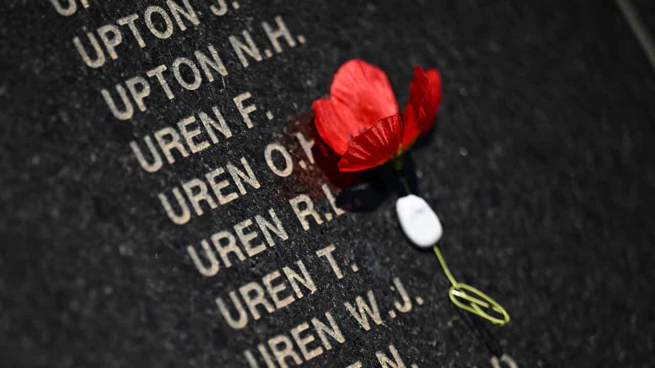 The poppy placed onto the memorial