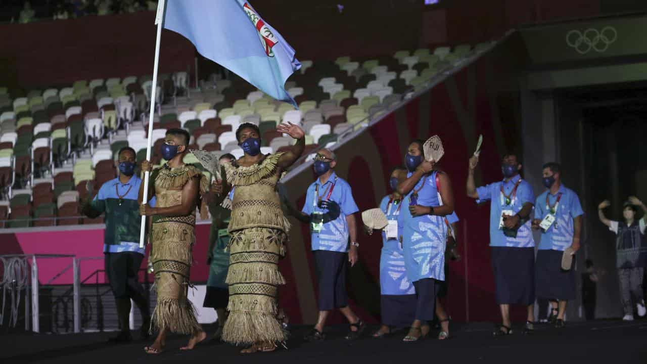 Rusila Nagasau and Jerry Tuwai lead out Fiji.