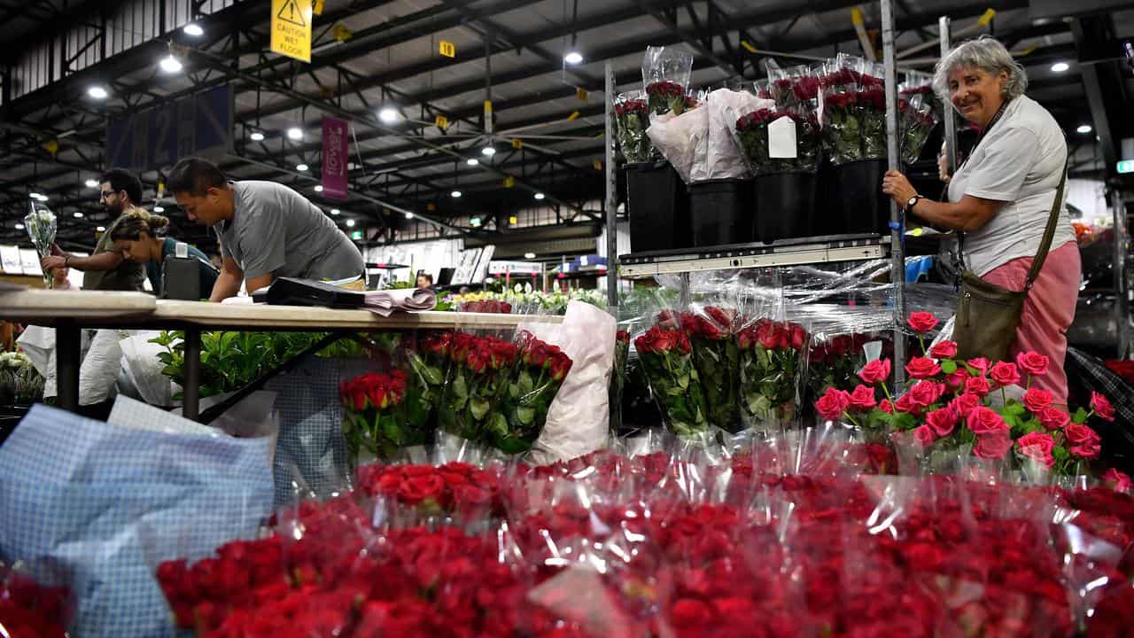 Woman looks at bunches of roses