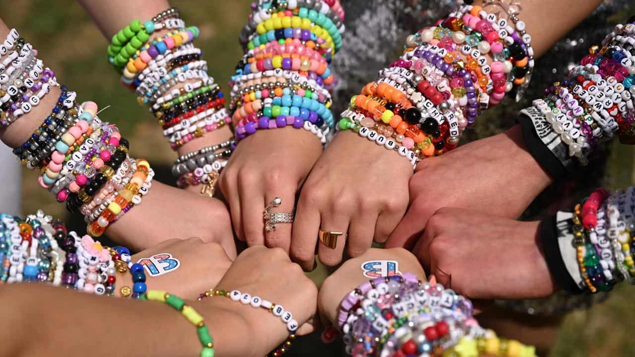 Taylor Swift fans show off their beaded bracelets.