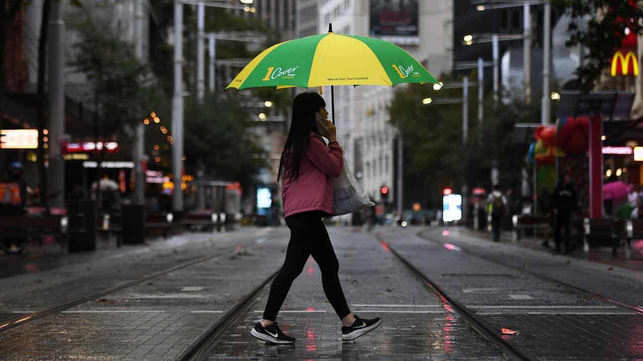 People walk with umbrellas in Sydney