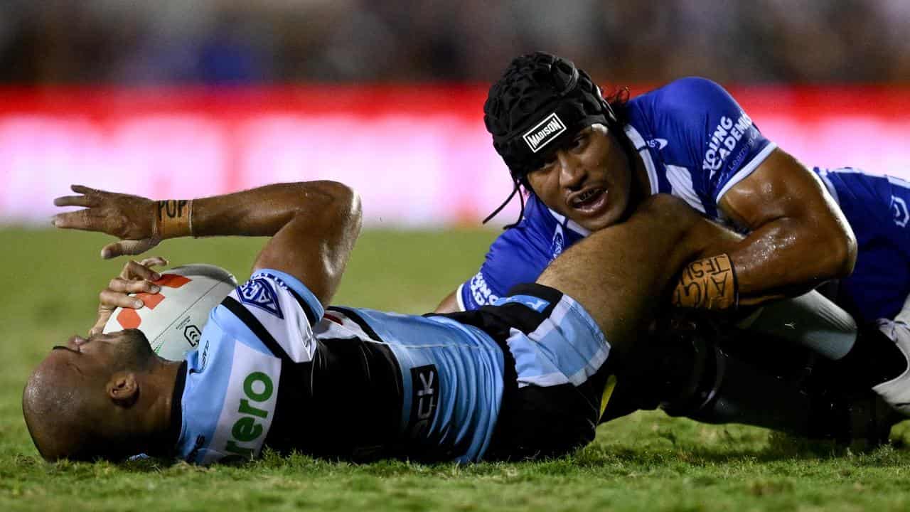 Stephen Crichton (right) makes a tackle against the Sharks. 