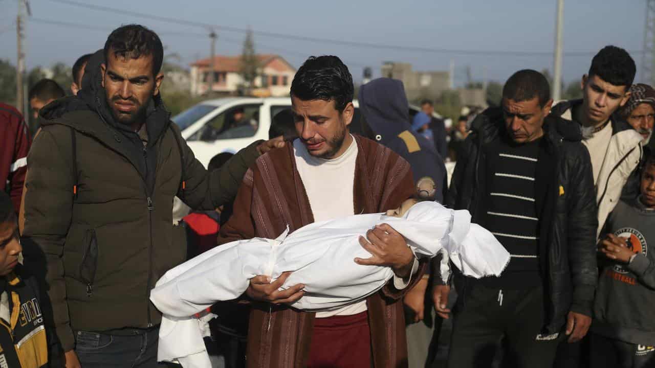 A Palestinian man holds the body of his young son in Khan Younis