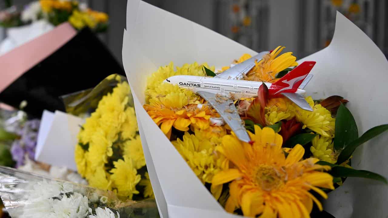 A model Qantas plane placed among flowers.