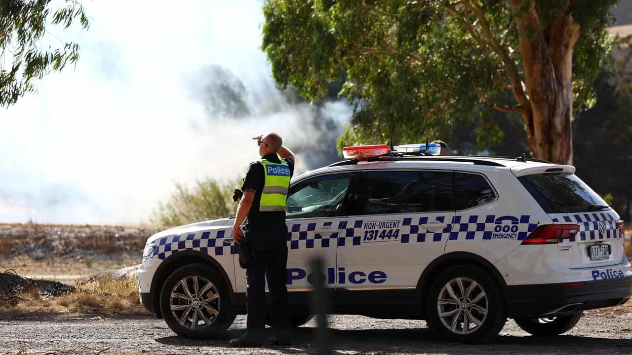 Police officers monitors the bushfire