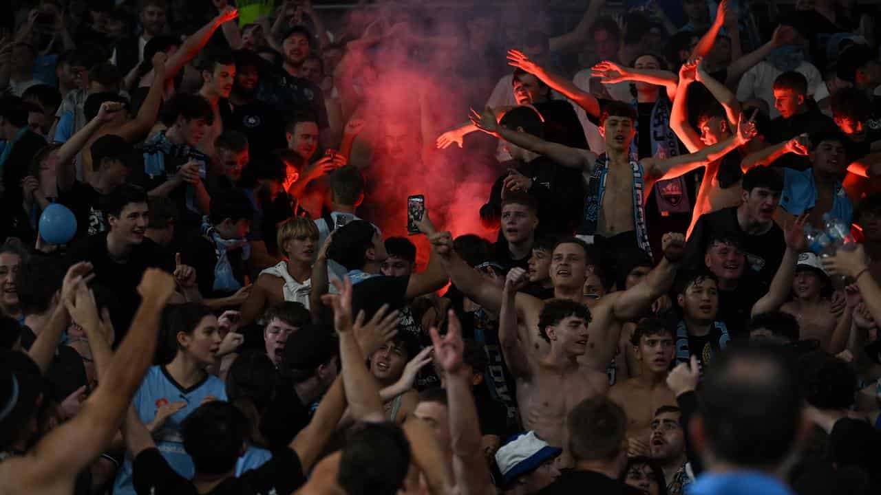 Sydney FC supporters light a flare at CommBank Stadium.