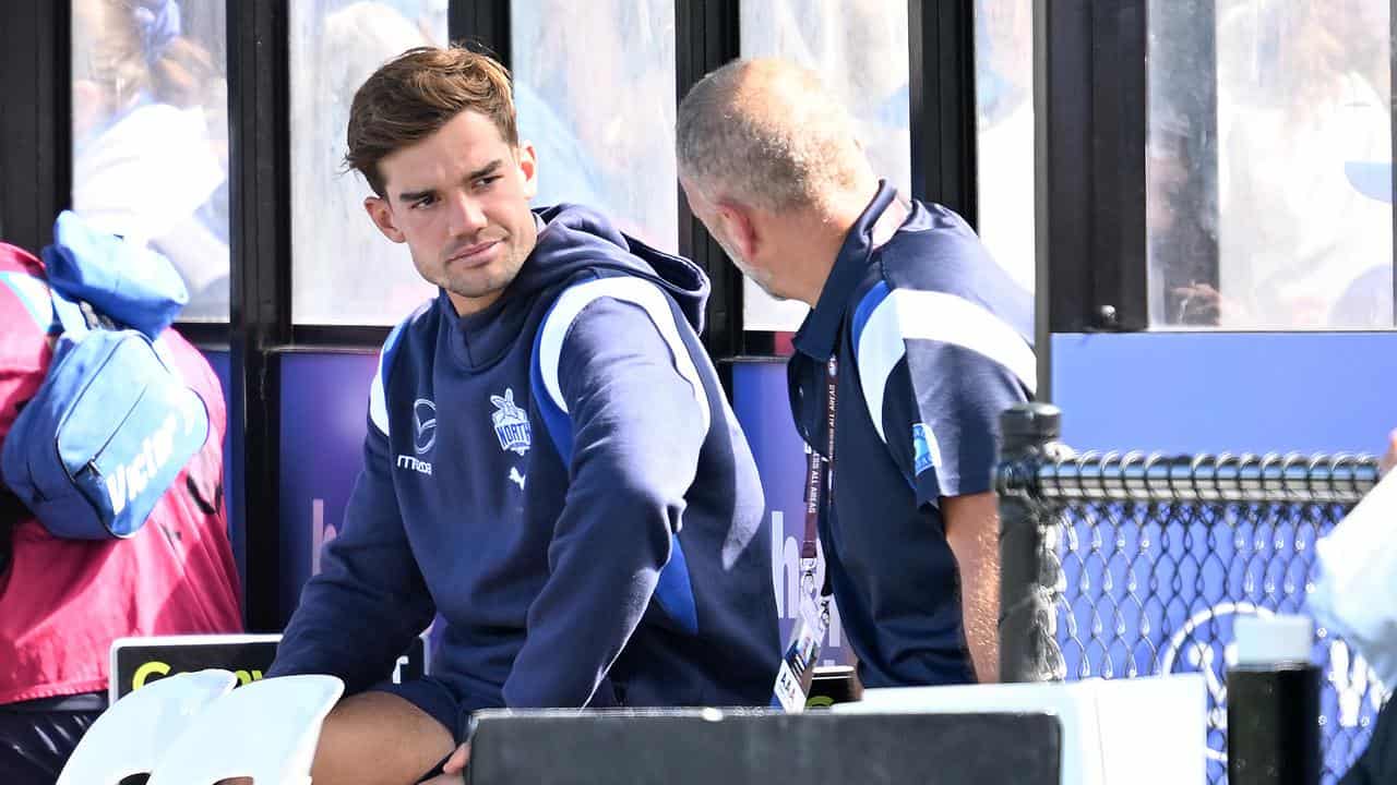 Jy Simpkin (left) on the bench at North Melbourne vs St Kilda.