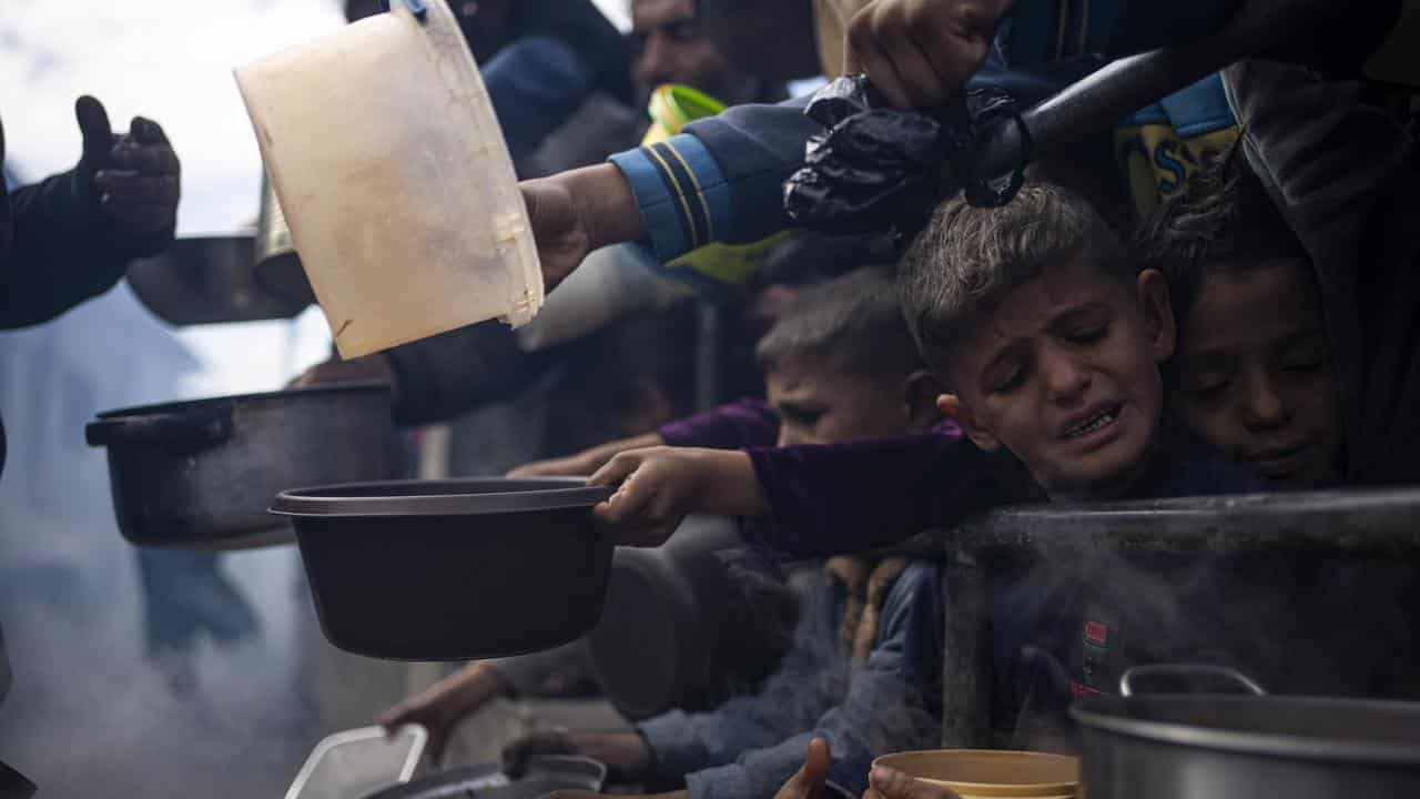 Palestinians line up for a free meal in Rafah, Gaza Strip