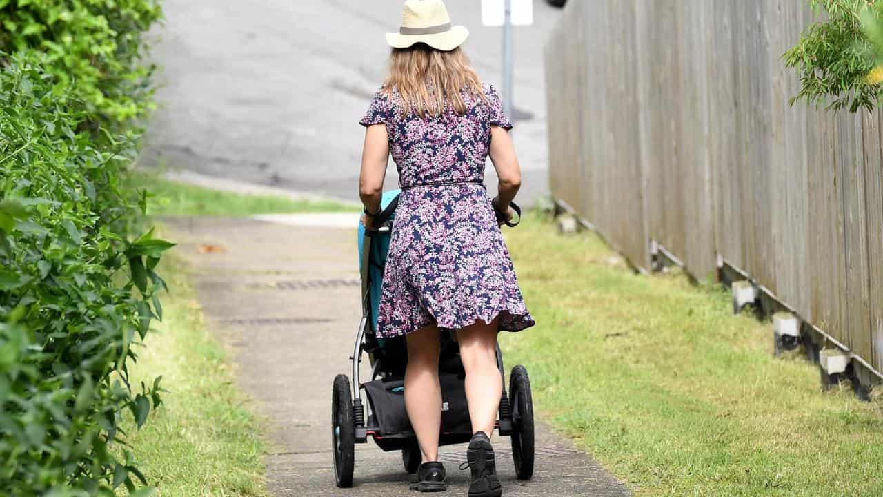 A mother pushes a stroller.