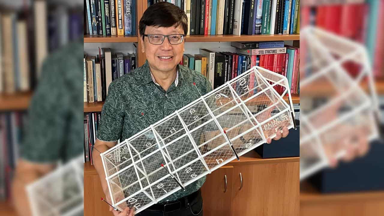 Professor Chien Ming Wang holds a model of the SeaFisher pen.