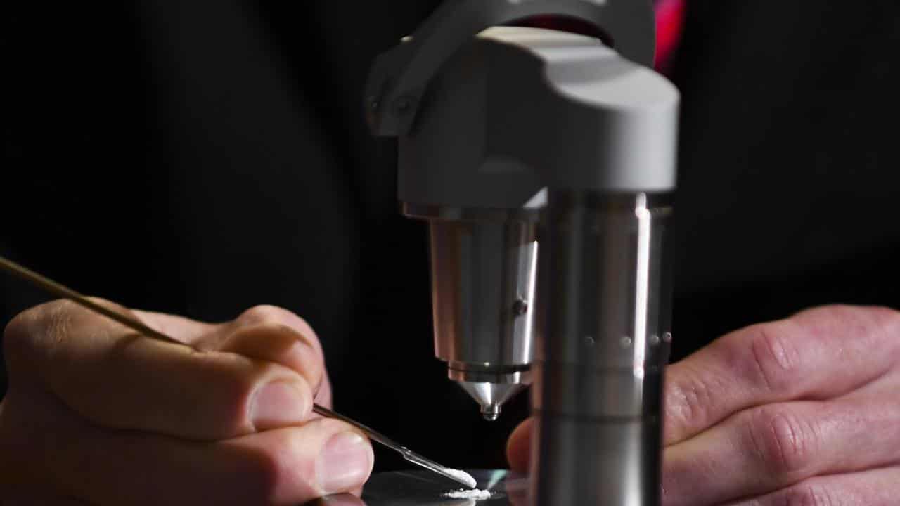 A man uses the Compact FTIR Spectrometer pill testing machine