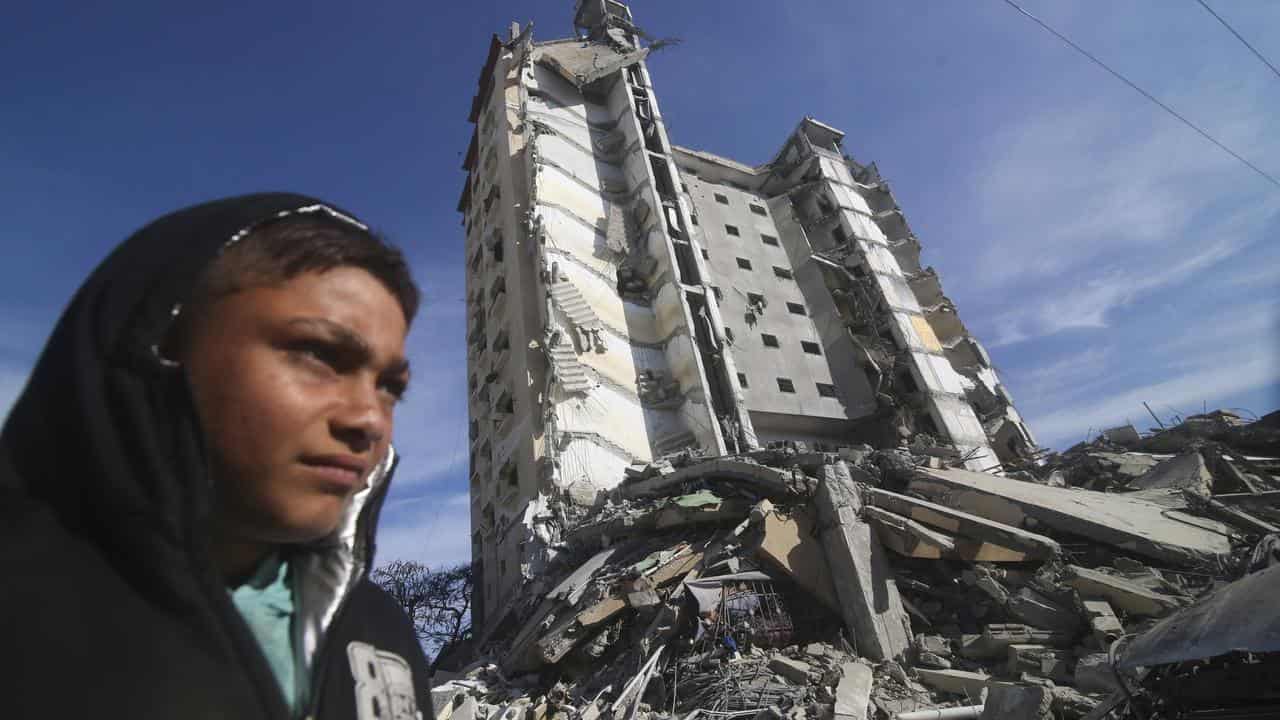 A woman at a building destroyed in an Israeli strike in Rafah