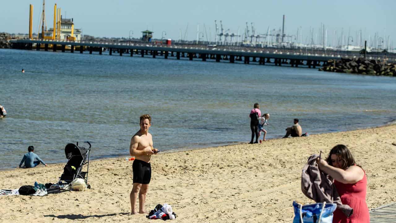 People are seen on St. Kilda’s Beach in Melbourne