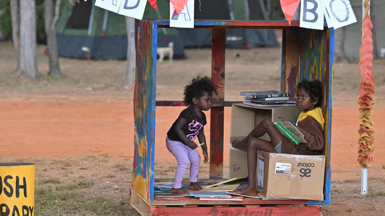 Children reading books during the Garma Festival in 2023