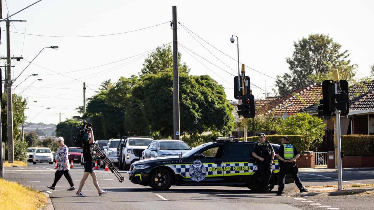 Members of Victoria Police block off Albert Street.