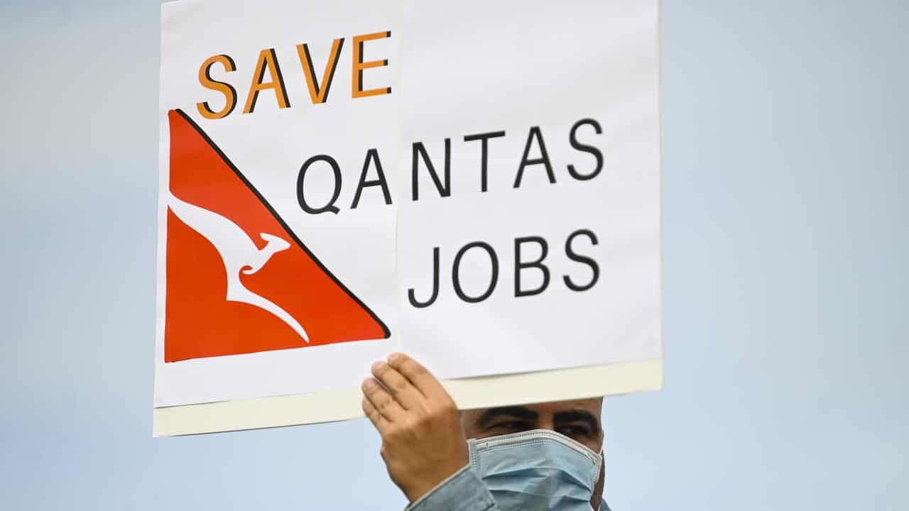 A Qantas employee holds a sign (file image)