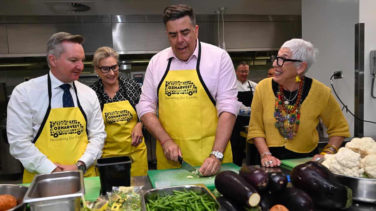 Chris Bowen and Milton Dick cutting vegetables