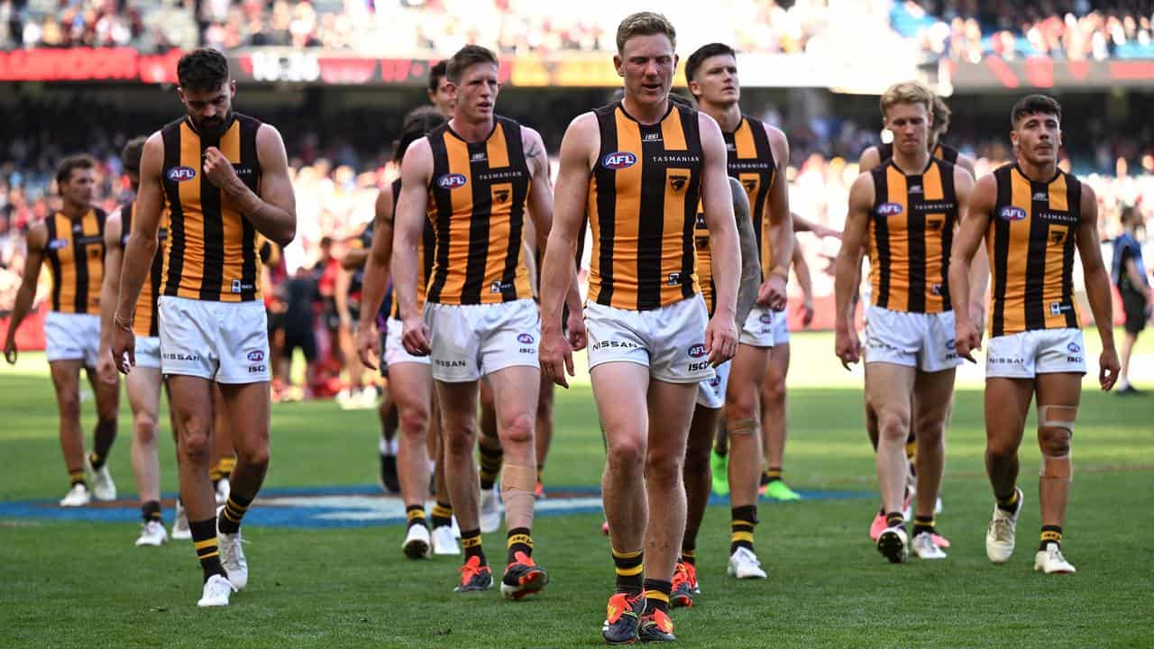 Disappointed Hawthorn players leave the field.