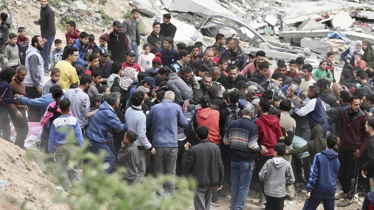 Palestinians collect the humanitarian aid airdropped into Gaza City